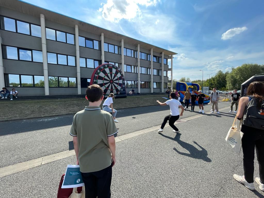 étudiant qui lance un ballon sur une cible géante lors de sa journée d'intégration.