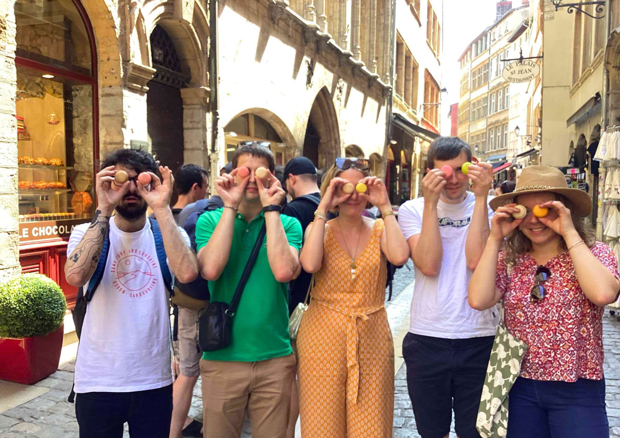 Photo d'une équipe qui cachent leurs yeux avec un macaron lors d'un rallye gourmand