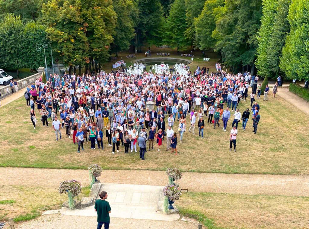 Photo d'une entreprise avec de nombreux collaborateurs dans un lieu de séminaire en extérieur