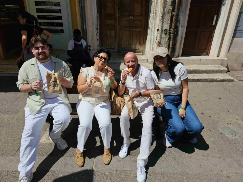 Une équipe savourant sa dégustation sur un banc lors d'une aventure gourmande à Marseille