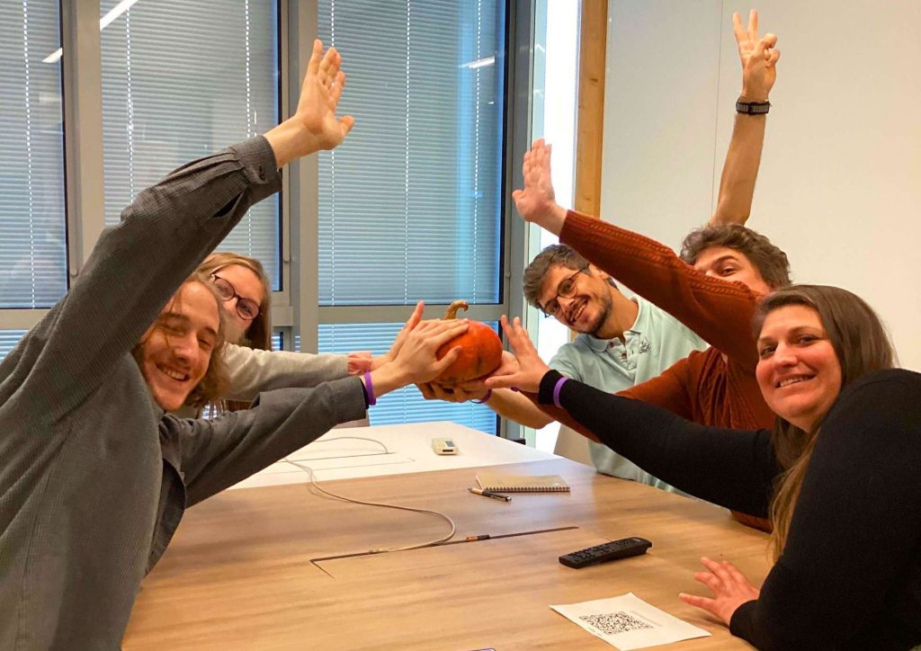 Photo d'une équipe qui prend la pose en intérieur dans leur locaux