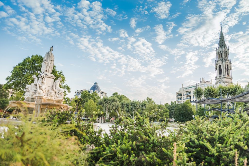 Jardin avec une fontaine et une cathédrale en arrière plan