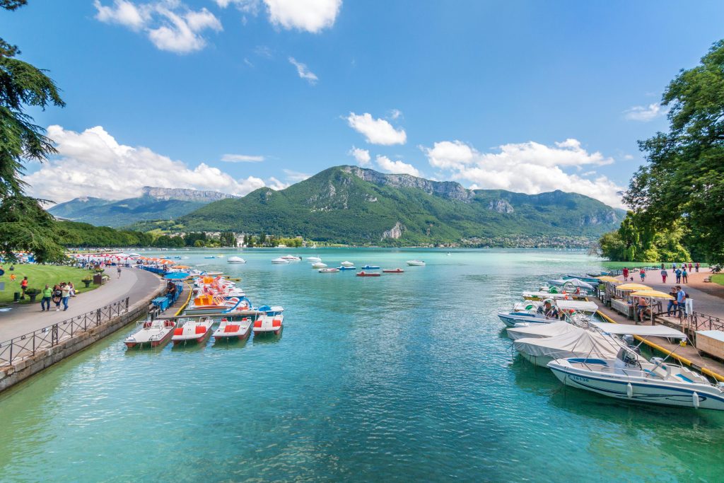 Vue imprenable sur le lac d'Annecy avec les petits bateaux et la montagne en fond