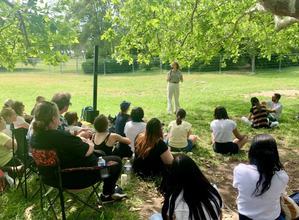 Une animatrice briefe des olympiades à un groupe de collaborateurs dans le parc Borély