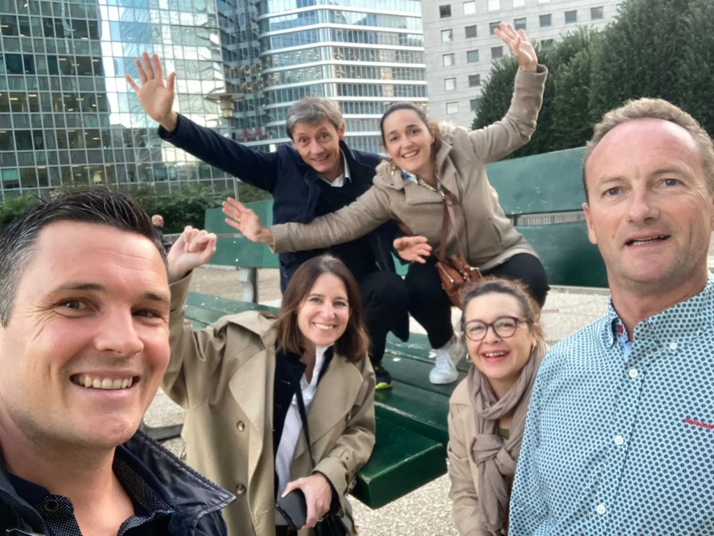 Une équipe réalisant un défi photo sur une sculpture street-art de la Défense