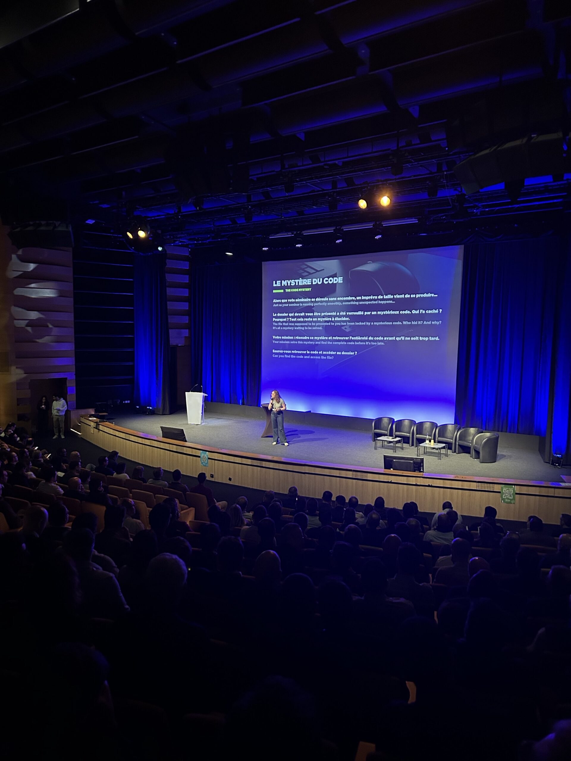 Photo de Eléa qui présente dans une salle de conférence un team building enquête aux collaborateurs qui vont jouer