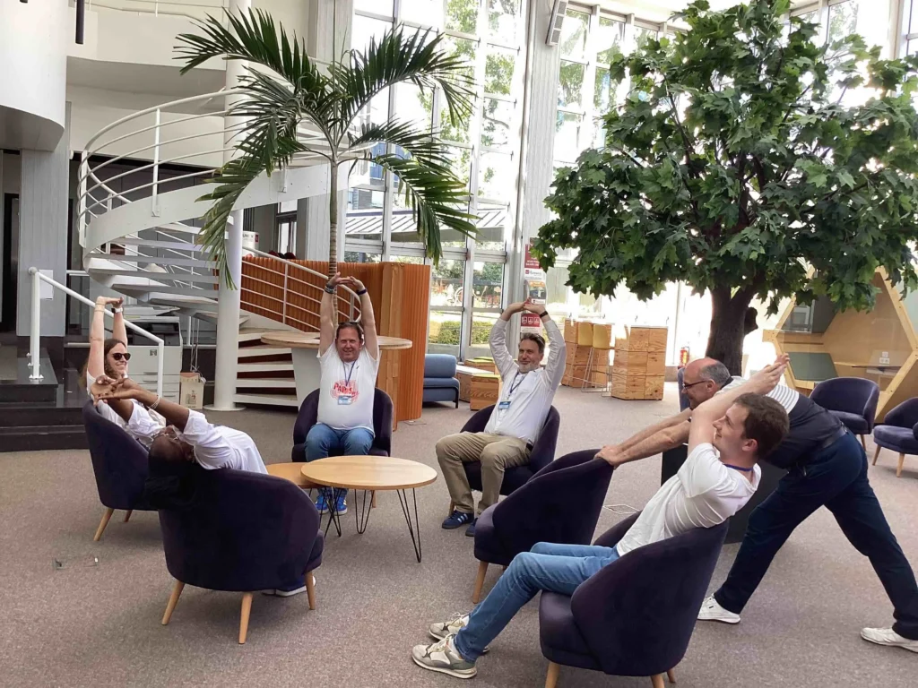 Une équipe dans un hall qui fait des exercices de relaxation