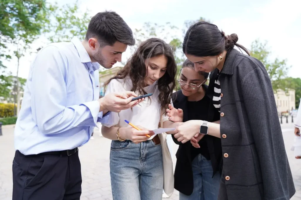 Une équipe déchiffre un indice sur son smartphone en pleine rue, idée de chasse aux trésors urbaine à tester entre collègues.